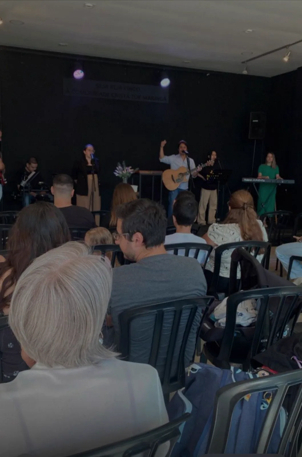 A igreja reunida no culto de domingo, de frente para o louvor